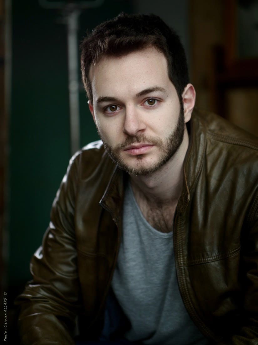 Portrait en blouson de cuir marron, sur fond sombre